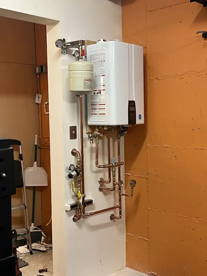 Plumbing technician inspecting water heater connections in Marlborough
